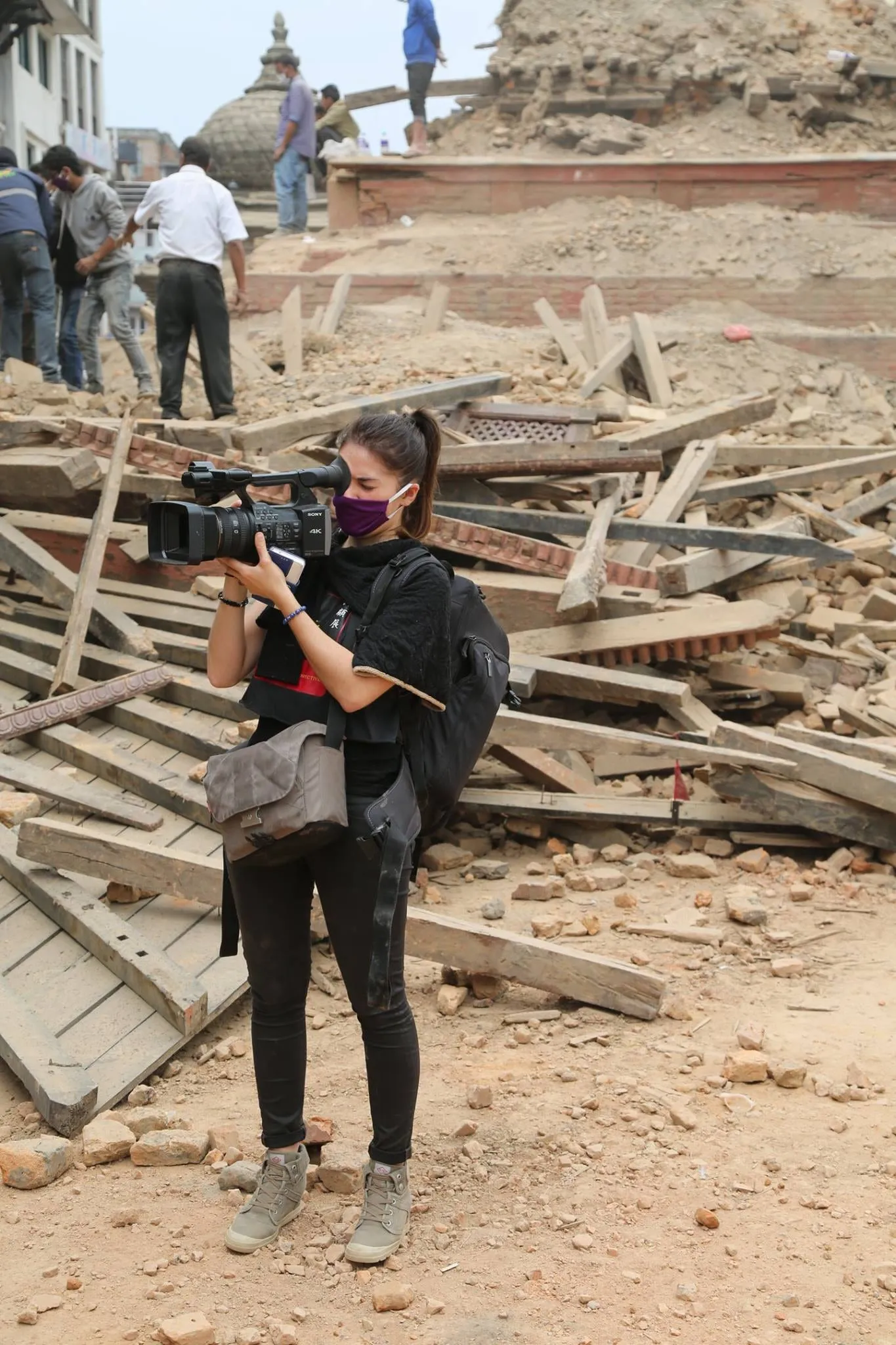 susana darcambel portant une camera au milieu des décombres lors du tremblement de terre au Nepal en 2015