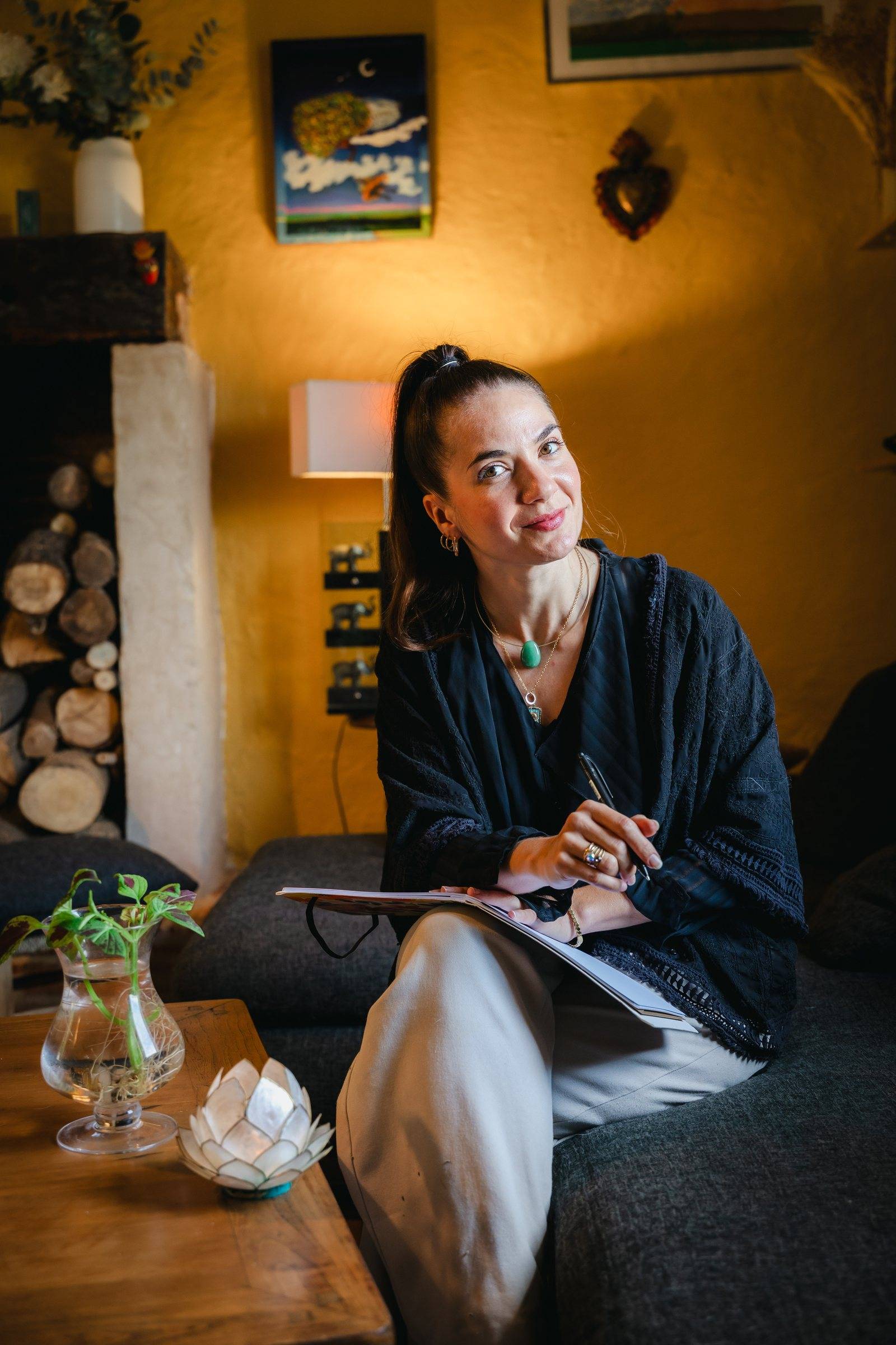Susana d'Arcambel, coach de transitions de vie, assise dans son salon avec un carnet