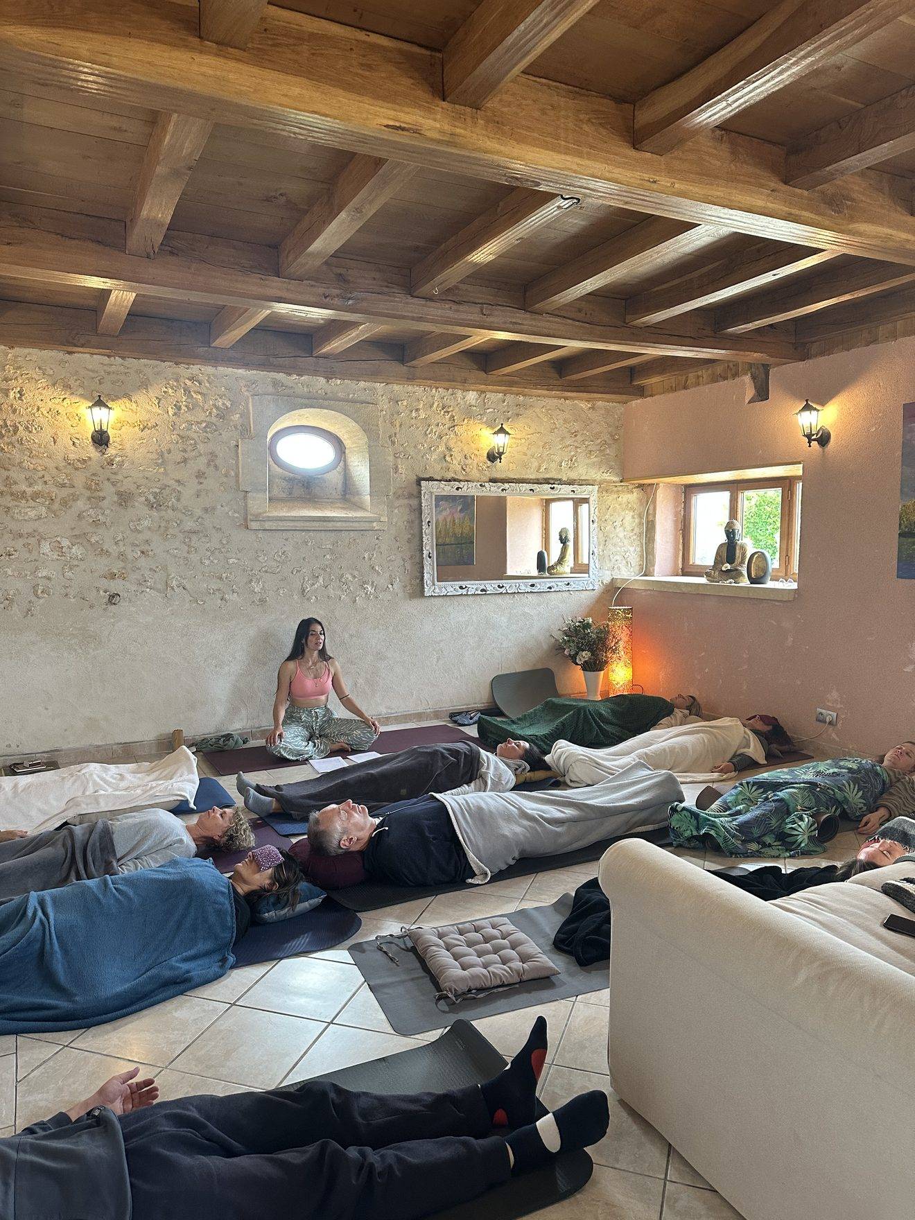 Participantes allongées en relaxation sous les poutres de la salle pendant l'Escapade Fleur de Cactus